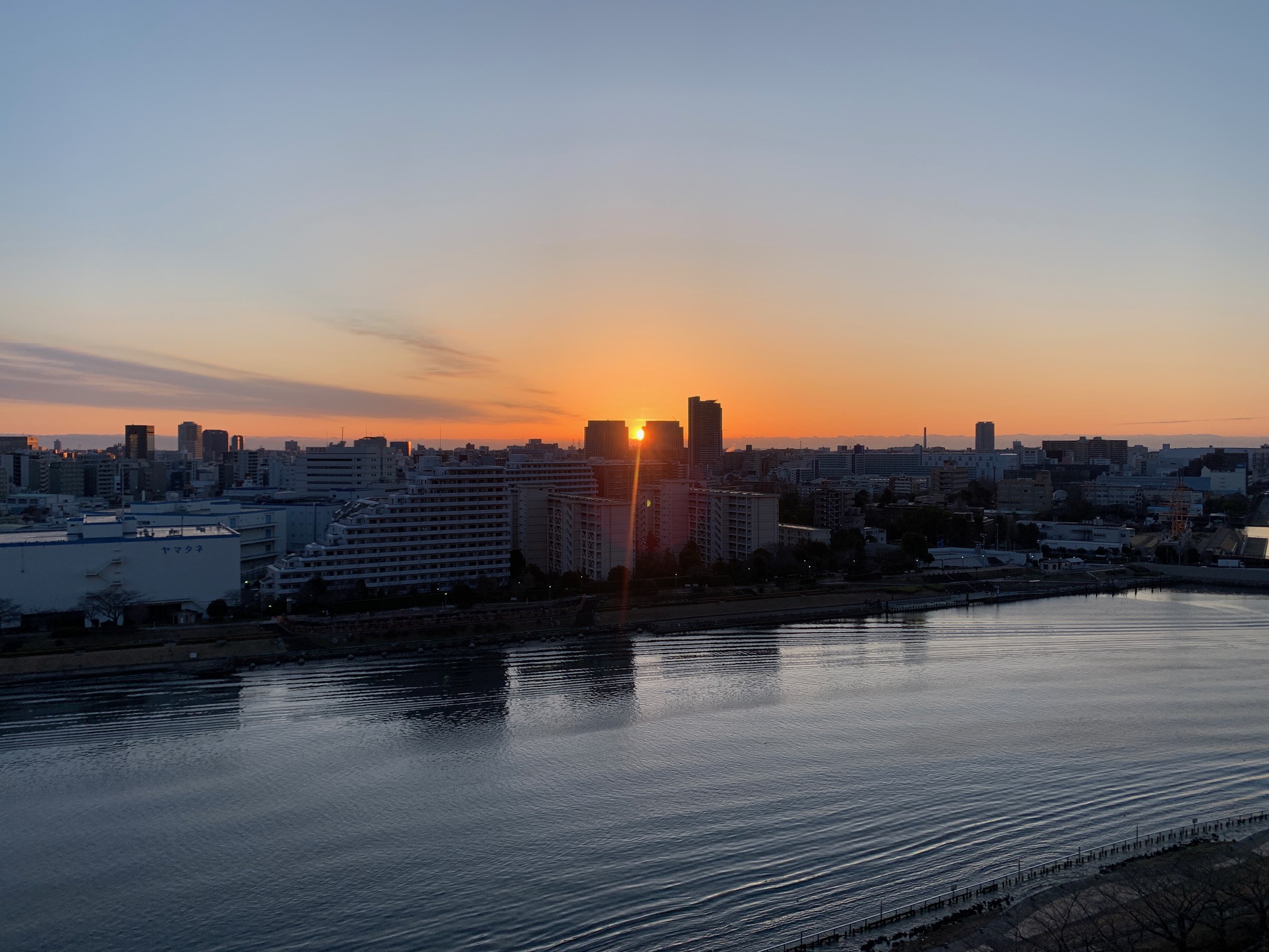 ビルとビルの間から明るい朝陽「時間を大切に」